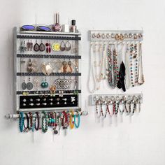 a wall mounted jewelry rack with multiple necklaces and earring holders on it's sides