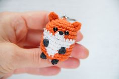 a small crocheted fox keychain in someone's hand