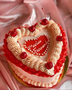 a heart shaped cake with cherries on top