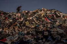 two men standing on top of a pile of clothes