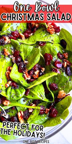 a salad with lettuce, cranberries and walnuts on it in a glass bowl