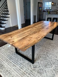 a large wooden table sitting on top of a rug