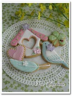 decorated cookies on a doily with flowers and hearts in the shape of letter e