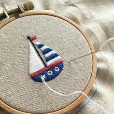 a close up of a embroidery on a piece of cloth with a sailboat in the middle