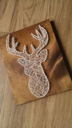 a string art deer head on a wooden board