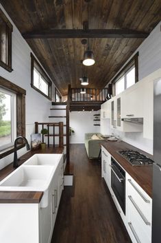 a kitchen with wooden ceiling and white cabinets