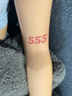 a woman with a red number 55 tattoo on her arm