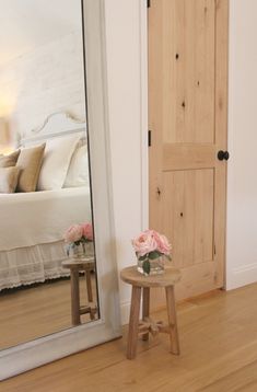 a bedroom with white walls and wooden floors