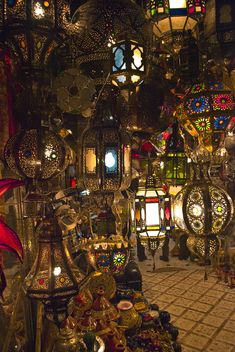 many lamps are hanging from the ceiling in a shop