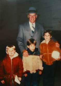 an older man standing next to two young boys