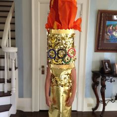 a young child wearing a gold sequin olympic costume