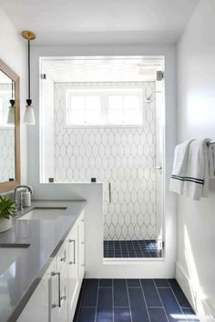 a bathroom with blue and white tile floors and walls, along with a walk in shower