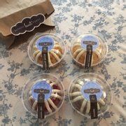 four plastic containers with cookies in them on a table