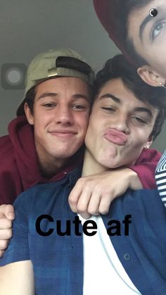 two young men are hugging each other with the caption cute af on their forehead