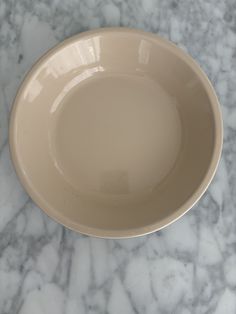 a white bowl sitting on top of a marble counter