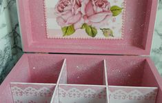 an open pink box with roses painted on it