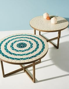 two tables sitting on top of each other in front of a blue and white wall