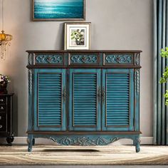 a blue cabinet in a living room with pictures on the wall