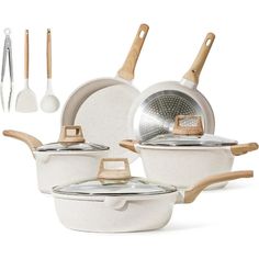 an assortment of white pots and pans with wooden spoons, spatulas and utensils