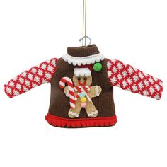 a christmas sweater ornament hanging on a string with candy canes and a gingerbread man