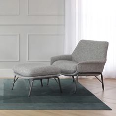 a chair and ottoman on a rug in an empty room