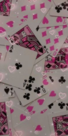 many playing cards are laying on top of each other with pink and black hearts all over them