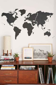 a wall with a world map on it and some bookshelves in front of it