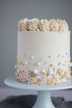 a white cake with sprinkles and confetti on top