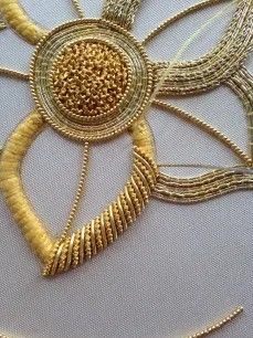 an intricate gold brooch is displayed on a white surface