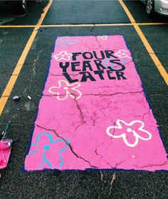 the sidewalk has been decorated with pink and blue chalk, which says four years later