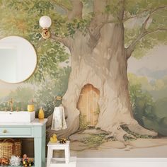 a bathroom with a tree painted on the wall next to a white sink and mirror