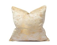 a white and gold pillow on a white background