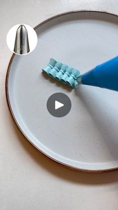 the toothbrush is being used to brush the teeth with blue bristles on a white plate