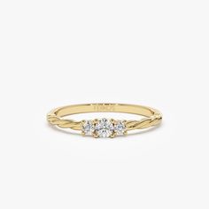 the three stone ring in yellow gold with two diamonds on each side and a small round diamond