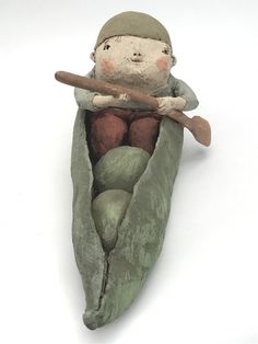 a clay figurine is sitting in a green boat