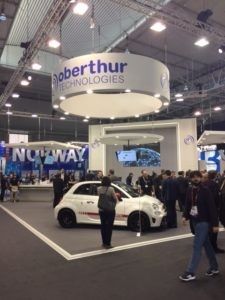 people are standing in front of a car on display at an auto show with no way signs