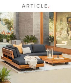 a couch sitting on top of a white rug next to a wooden table and chair