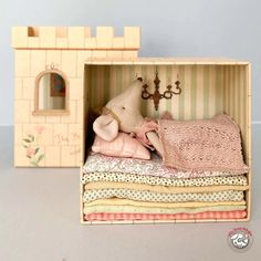 a doll house with a stuffed animal in it's bed next to a toy castle