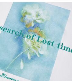 a white t - shirt with the words search of lost time on it and a flower