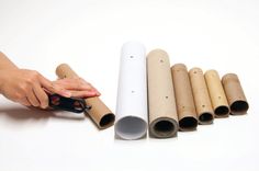 a person holding a pair of scissors in front of several rolled up rolls of paper