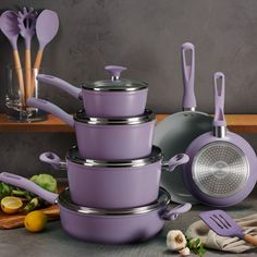 purple pots and pans are stacked on top of each other with utensils