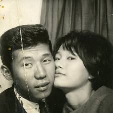 an old photo of a man and woman posing for the camera with their noses close to each other