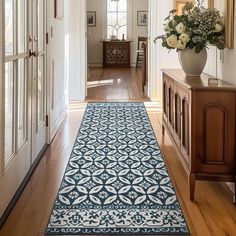 a blue and white runner rug in the hallway