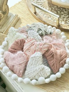 a white plate topped with lots of knitted hearts