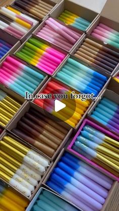 many different colored pencils in boxes on a table