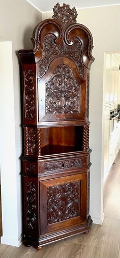 an ornate wooden cabinet in the corner of a room