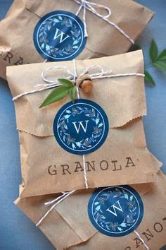 two brown paper bags tied with twine and some green leaves on top of them