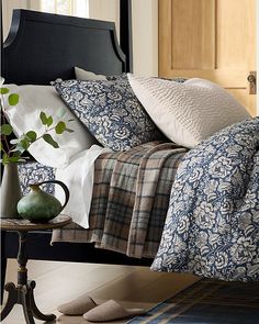 a bed with blue and white comforters on top of it