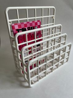 a magazine rack with pink and white checkered paper in it, sitting on a table