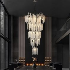 a large chandelier hanging from the ceiling in a room with black walls and chairs